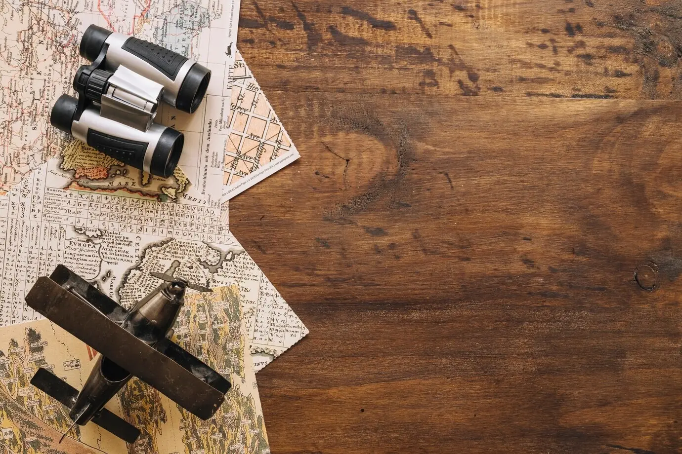 Flugzeug und Fernglas auf Landkarten